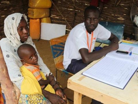 a man, woman, and a child sit behind a desk